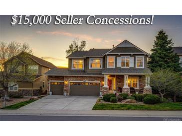 Inviting two-story home featuring a stone facade, well-manicured lawn, and a two-car garage, offering an appealing curb appeal at 4307 Lilly Gulch Trl, Castle Rock, CO 80109