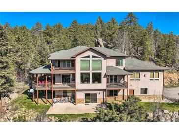 Spacious home with multiple balconies and large windows overlooking the surrounding forest and lush backyard at 9659 S Turkey Creek Rd, Morrison, CO 80465