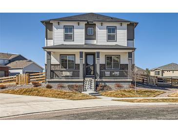 Charming two-story home featuring a welcoming front porch and neutral color palette at 10723 Sedalia St, Commerce City, CO 80022