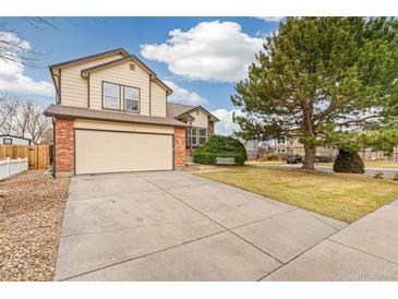Charming two-story home featuring a two-car garage, brick accents, and a well-maintained front yard with mature tree at 10663 Dexter Dr, Thornton, CO 80233