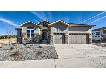Beautiful two-story home with a three car garage, stone accents, and a well manicured front yard at 574 Agoseris Way, Castle Rock, CO 80104