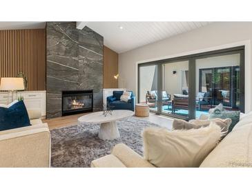 Bright living room with fireplace, wood accents, and sliding glass doors to outdoor patio at 2552 E Alameda Ave # 92, Denver, CO 80209