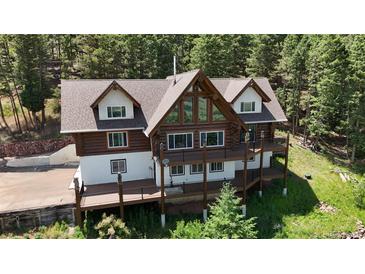 Stunning log home featuring a spacious deck perfect for entertaining and enjoying the surrounding mountain views at 13525 Woodmoor West Dr, Larkspur, CO 80118