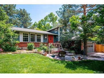 Charming home featuring a red door, brick accents, a swing, and lush landscaping at 6360 S Kendall St, Littleton, CO 80123