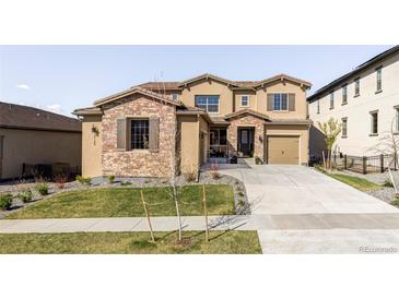 Charming two-story home with a stone facade, manicured lawn, and a welcoming front entrance at 2125 S Orion St, Lakewood, CO 80228