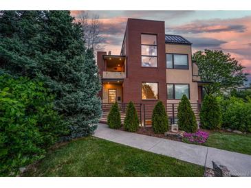 Beautiful two-story home featuring a well-manicured lawn and a brick facade at 402 Garfield St, Denver, CO 80206
