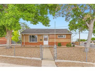 Charming single-story brick home featuring a well-kept front yard and a secure chain-link fence at 6930 Warren Dr, Denver, CO 80221