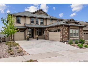 Two-story house with stone and siding exterior, two-car garage, and landscaping at 8107 Arapahoe Peak St, Littleton, CO 80125
