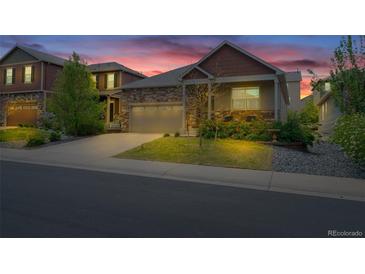 Charming two-story home with a stone facade, a two-car garage, and beautifully landscaped yard at 5741 Echo Park Cir, Castle Rock, CO 80104