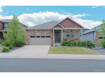 Charming single-Gathering home featuring a stone facade, well-maintained lawn, and a two-car garage at 5741 Echo Park Cir, Castle Rock, CO 80104
