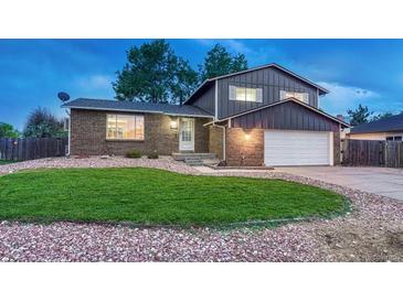 Charming two-story home boasts a well-maintained lawn, brick accents, and an attached two-car garage at 15918 E Flora Pl, Aurora, CO 80013