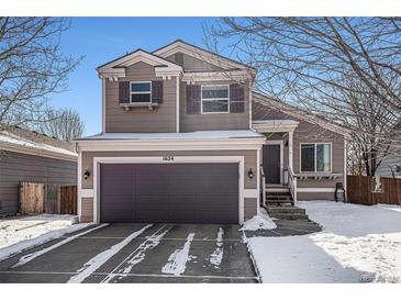 Two-story home with a two-car garage, light brown siding, and unique dark brown window shutters at 1624 Westin Dr, Erie, CO 80516