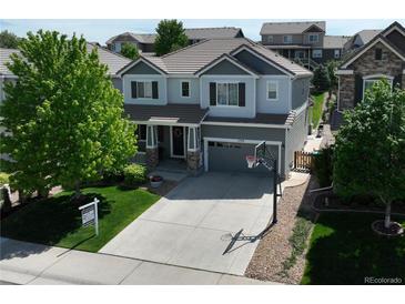 Two-story home with a gray exterior, landscaped yard, and a basketball hoop on the driveway at 2198 Broadleaf Loop, Castle Rock, CO 80109