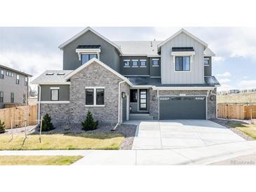 Beautiful two-story home with a stone facade and a two-car garage, enhancing its curb appeal at 14247 Beebalm Loop, Parker, CO 80134