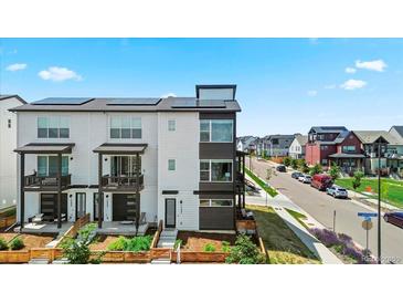 Modern townhome with solar panels, balcony, and manicured front yard at 16637 Shoshone St, Broomfield, CO 80023