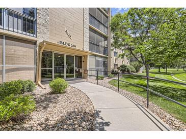 Inviting entrance to Building 209 with accessible ramp and well-maintained landscaping and stone entryway at 3124 S Wheeling Way # 102, Aurora, CO 80014