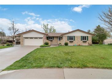 Charming brick home with a lush green lawn, attached garage, and inviting curb appeal at 6288 S Harlan Way, Littleton, CO 80123