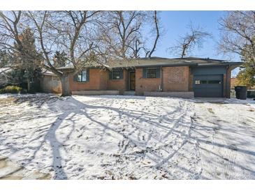 Brick ranch home with snow-covered yard and attached garage at 725 S Harrison St, Denver, CO 80209