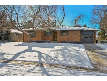 Brick ranch home with updated exterior, snow-covered lawn, and driveway at 725 S Harrison St, Denver, CO 80209