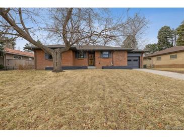 Charming brick home with a well-kept lawn and attached garage providing curb appeal at 725 S Harrison St, Denver, CO 80209