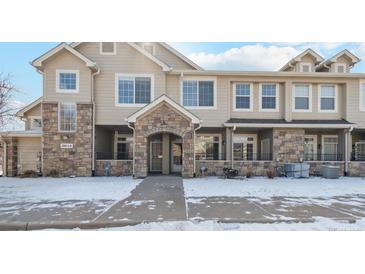 Inviting townhome exterior featuring stone accents, covered entryway, and well-maintained landscaping in a peaceful community at 10050 E Gunnison Pl # 805, Aurora, CO 80247