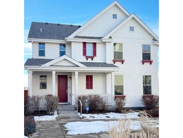 Charming two-story home features a classic white exterior with a welcoming front porch and a red front door at 8562 E 49Th Pl, Denver, CO 80238