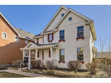 Charming two-story home with white siding, red window trim, and a welcoming front porch at 8562 E 49Th Pl, Denver, CO 80238