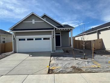 Charming single-Gathering home featuring a two-car garage, neutral siding, and a well-manicured lawn at 9463 Yampa Ct, Commerce City, CO 80022