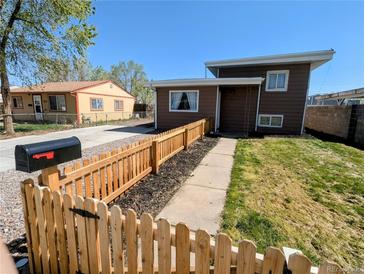 Charming two-story home with a well-maintained front yard and picket fence at 6710 Clermont St, Commerce City, CO 80022