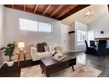 Bright living room featuring modern decor and a cozy seating area, wood ceilings, and large windows at 1830 Newland Ct # 321, Lakewood, CO 80214