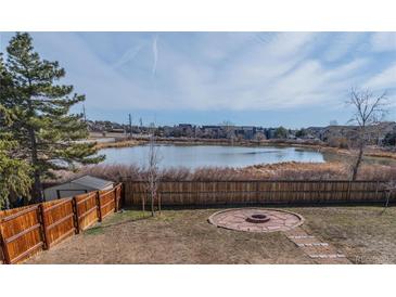 Spacious backyard features a lovely fire pit area and scenic pond views at 4328 S Carr Ct, Littleton, CO 80123