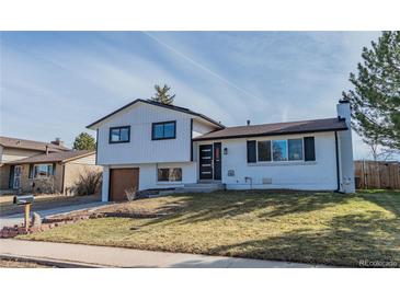 Charming two-story home with white painted brick, updated black trim, and attached garage on a sunny lot at 4328 S Carr Ct, Littleton, CO 80123