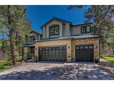 Inviting two-story home with a stone facade and attached three-car garage at 1410 Old Sequoia Ct, Franktown, CO 80116