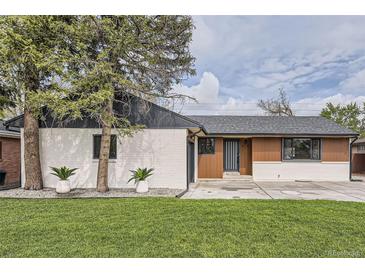 Charming home with a manicured lawn, trees, and updated exterior featuring light colored brick and modern design accents at 920 S Hudson St, Denver, CO 80246