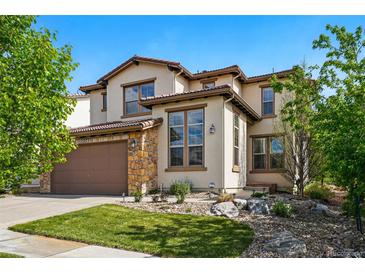 Inviting two-story home boasts a beautifully landscaped yard, stone accents, and a two-car garage at 15275 W La Salle Ave, Lakewood, CO 80228