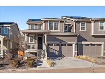 Charming townhome featuring a two-car garage, welcoming front porch, and modern architectural details at 9536 Richfield St, Commerce City, CO 80022