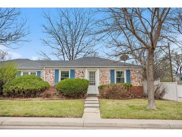 Charming brick ranch home with blue shutters and landscaped front yard at 6330 E 13Th Ave, Denver, CO 80220