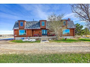 Charming log home featuring a covered porch, dormer windows, and inviting curb appeal at 48155 E 56Th Ave, Bennett, CO 80102