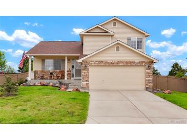Charming two-story home featuring stone accents, a covered porch, and an attached two car garage at 4873 Eckert St, Castle Rock, CO 80104