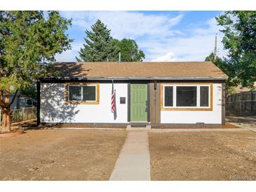 Charming single-story home featuring a green door, wood accents, and new windows at 3980 S Hazel Ct, Englewood, CO 80110