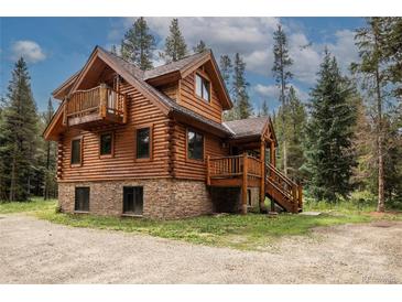 Charming log cabin with a stone foundation, wooden decks, and surrounded by tall pine trees at 5724 Highway 9, Breckenridge, CO 80424