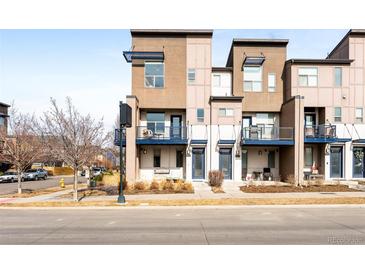 Modern townhome exterior with balconies and contemporary design elements, showcasing curb appeal at 10305 Martin Luther King Blvd, Denver, CO 80238