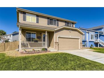 Inviting two-story home featuring a porch swing, well-kept lawn, and a two-car garage at 5090 Miriam Ln, Parker, CO 80134
