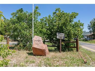 Louviers, Colorado entrance featuring a rock displaying its name with wooden split rail fence, and ample foliage at 7801 Valley View St, Louviers, CO 80131