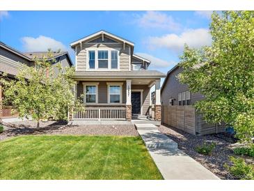 Charming two-story home featuring a welcoming front porch, landscaped lawn, and a well-maintained exterior at 15957 E Elk Pl, Denver, CO 80239