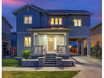 Charming two-story home featuring a covered front porch, well-manicured lawn, and convenient attached carport at 8444 E 55Th Pl, Denver, CO 80238
