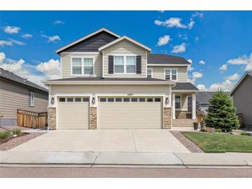 Home featuring a three-car garage, stone accents, and a well-manicured lawn at 6401 Leilani Ln, Castle Rock, CO 80108