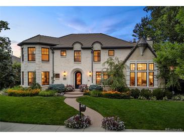 Elegant white brick home features manicured lawn, lush landscaping and timeless architectural design at 1027 S Fillmore Way, Denver, CO 80209