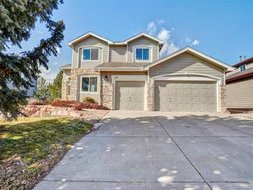 Charming two-story home featuring a stone facade, a large driveway, and an attached two-car garage at 9711 Millstone Ct, Highlands Ranch, CO 80130