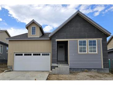 New build home featuring a partial beige and grey exterior with an attached two-car garage and covered porch at 17075 W 92Nd Loop, Arvada, CO 80007